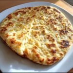 A delicious, golden-brown Cottage Cheese Flatbread served on a white plate, ready to eat.
