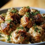 A bowl of Garlic Butter Meatballs, glistening with sauce and garnished with fresh parsley.