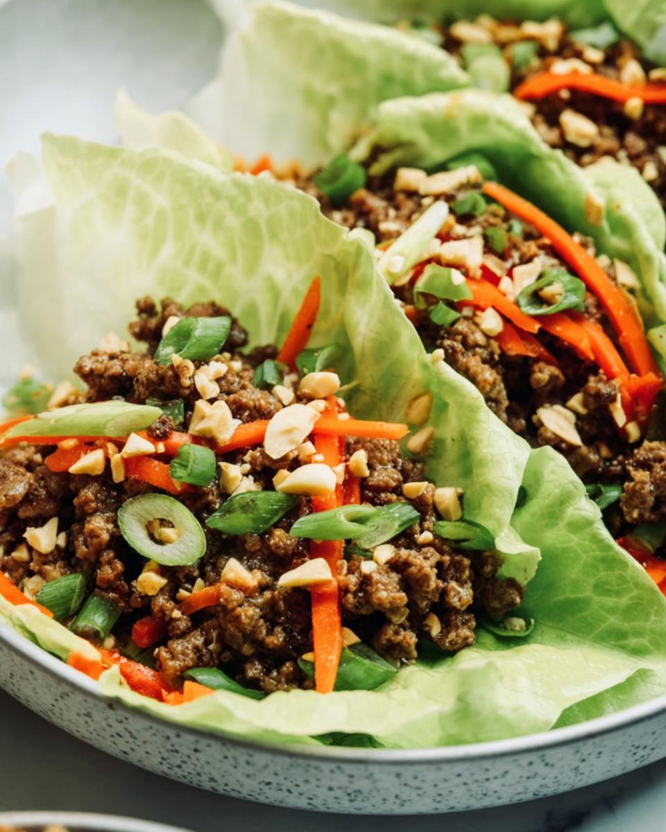 Close-up of Ground Beef Lettuce Wraps with carrots, green onions, and peanuts.