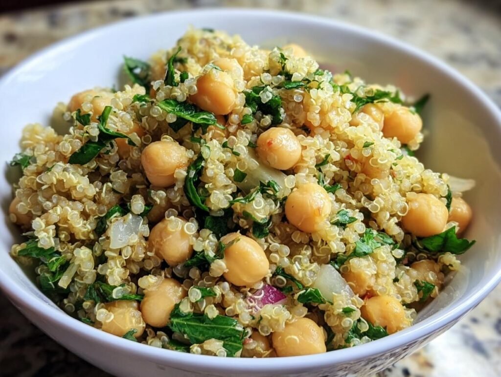 Close-up of Lemon Herb Quinoa Chickpeas in a white bowl, showcasing the fresh herbs and fluffy quinoa.