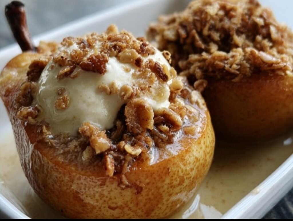 Two baked pears with oat topping and a scoop of vanilla ice cream on a white plate. Baked Pears With Oat.