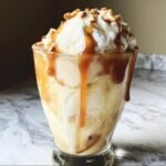 A decadent Caramel Apple Cider Float with ice cream, whipped cream, caramel drizzle, and chopped nuts.