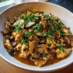 Bowl of Creamy Turkey Stroganoff, lightened, with mushrooms and fresh parsley garnish.