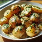 Close-up of Garlic Sauce Baby potatoes, garnished with fresh herbs, served in a bowl.