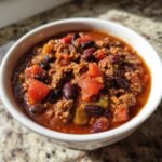 A bowl of hearty Ground Turkey Chili (Stovetop) with ground turkey, tomatoes, beans, and peppers.