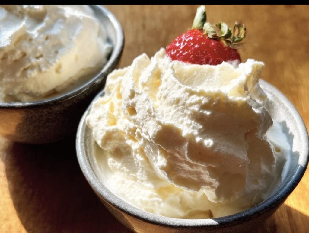 Two bowls of keto cheesecake fluff, one topped with a fresh strawberry. Creamy and delicious!