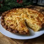 A delicious Potato Bacon Pie with a slice cut out, revealing the savory filling. Golden brown crust.