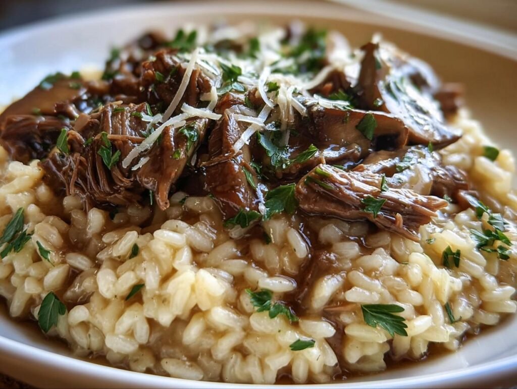 A plate of creamy roast and risotto topped with tender shredded meat, mushrooms, parmesan, and fresh parsley.