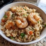 Bowl of Shrimp Fried Rice with large shrimp, rice, peas, carrots, and green onions.