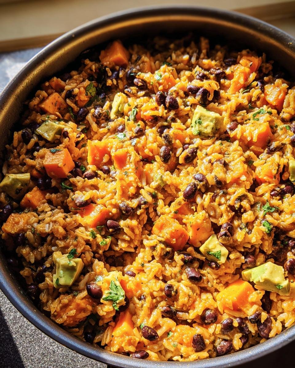 A vibrant Sweet Potato, Black Bean and Rice Skillet with avocado, ready to serve.
