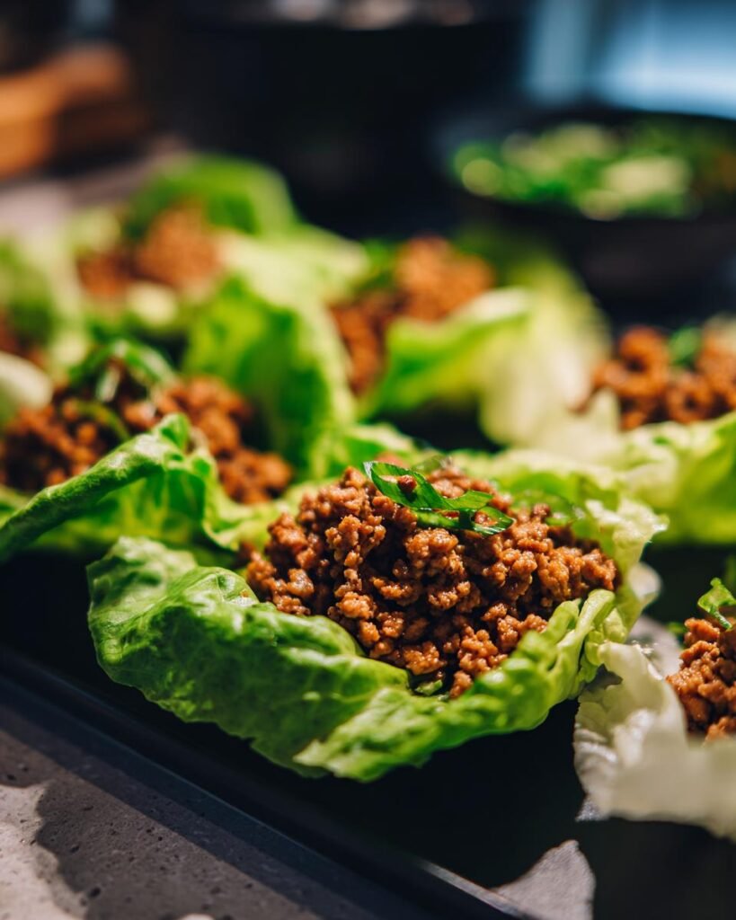 Close-up of Turkey Lettuce Wraps (PF-Style) on a platter, garnished with green onions.