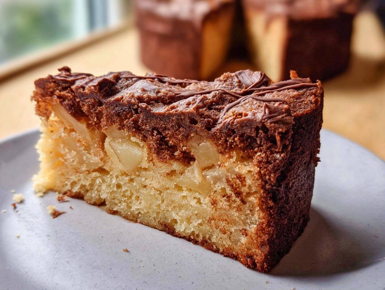 A slice of moist apple healthy cake recipe with a chocolate drizzle on top, showcasing chunks of apple within.