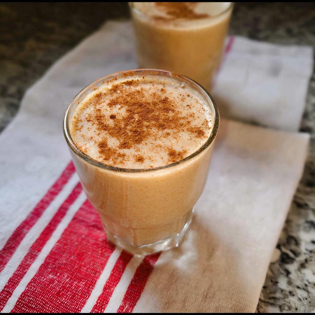 A refreshing Apple Cinnamon Smoothie topped with a sprinkle of cinnamon in a glass.