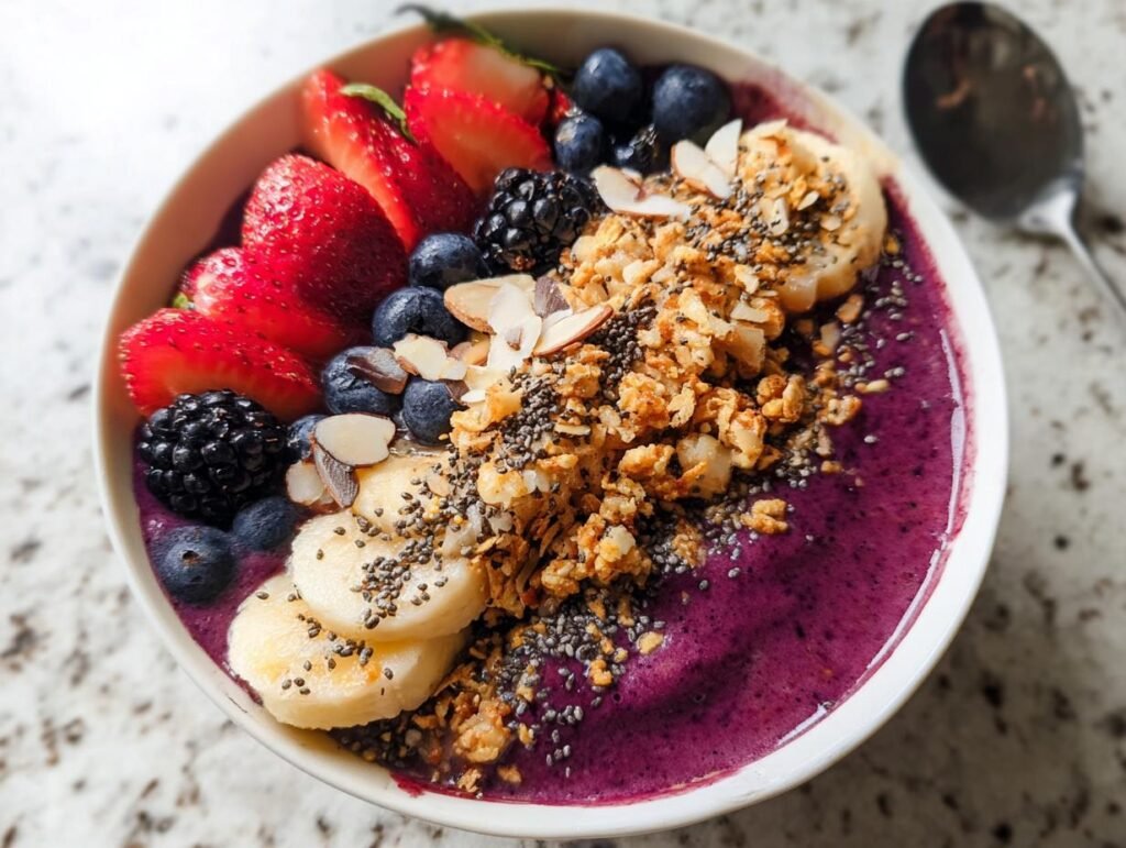 A vibrant Healthy Breakfast Smoothie Bowl topped with fresh strawberries, blueberries, blackberries, banana slices, granola, and chia seeds.